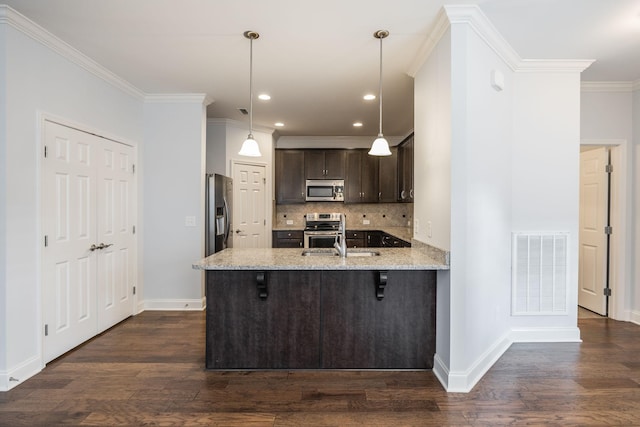 kitchen with light stone counters, appliances with stainless steel finishes, a peninsula, visible vents, and dark brown cabinets