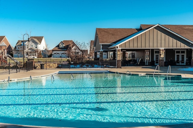 view of pool featuring a residential view, fence, and a patio
