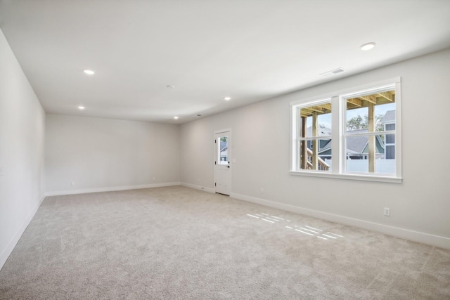 unfurnished room featuring baseboards, a healthy amount of sunlight, recessed lighting, and light colored carpet