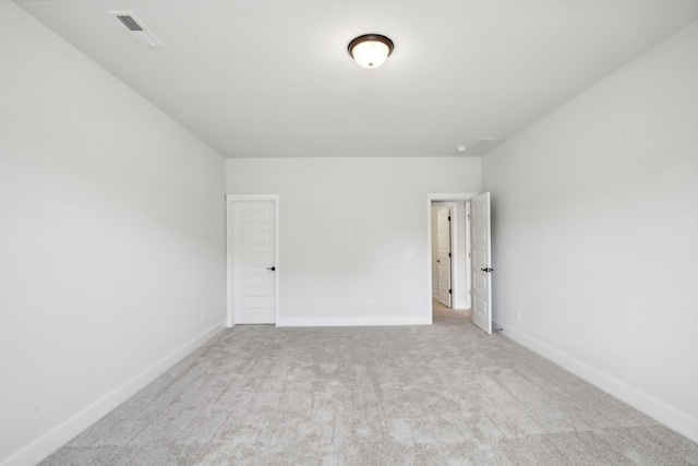empty room with carpet flooring, baseboards, and visible vents