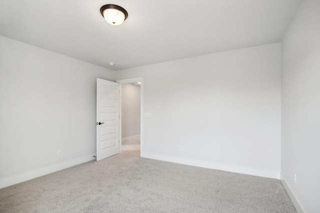spare room featuring carpet floors and baseboards