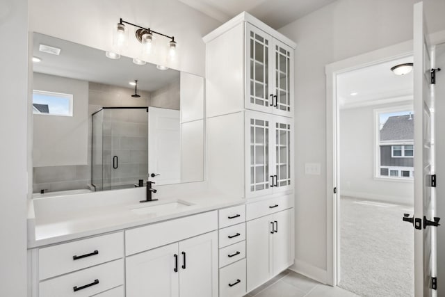 bathroom featuring a stall shower, baseboards, tile patterned flooring, and vanity