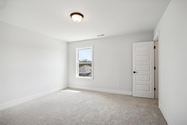 carpeted empty room featuring baseboards and visible vents