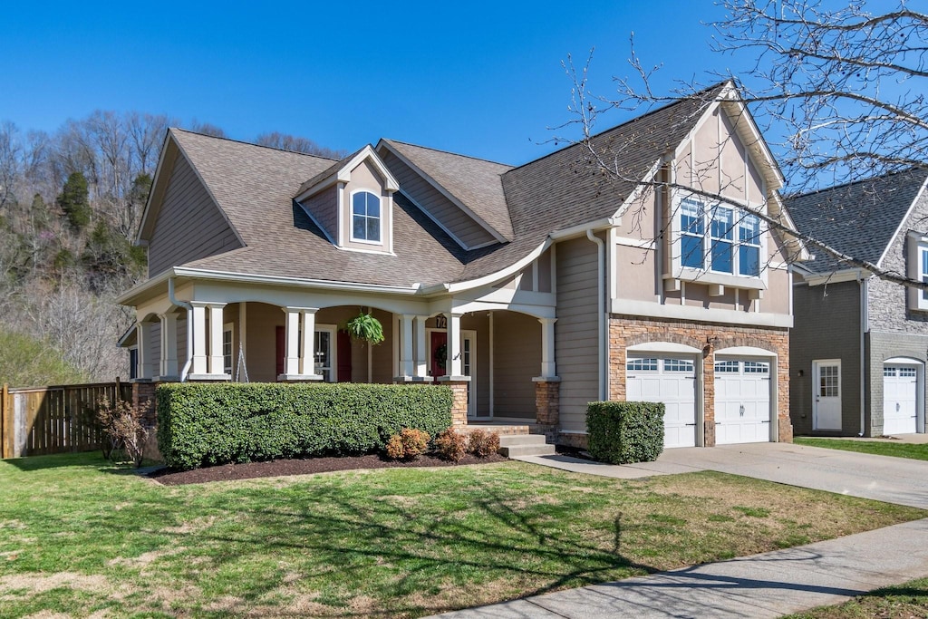 view of front of house featuring a front lawn, a porch, a garage, and concrete driveway
