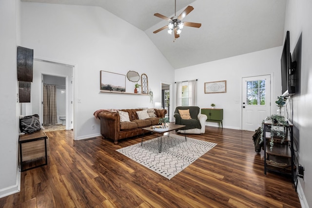 living area featuring baseboards, high vaulted ceiling, wood finished floors, and a ceiling fan