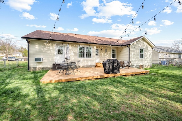 back of property featuring fence, a deck, and a yard