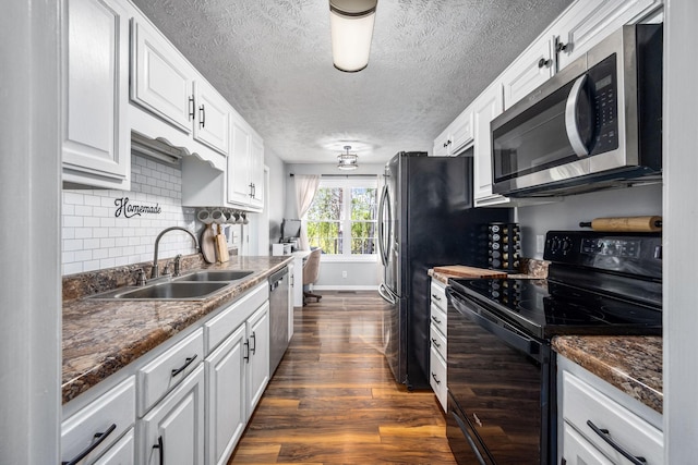 kitchen with decorative backsplash, white cabinets, dark wood finished floors, appliances with stainless steel finishes, and a sink