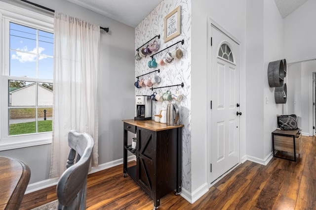 foyer featuring baseboards and dark wood-type flooring