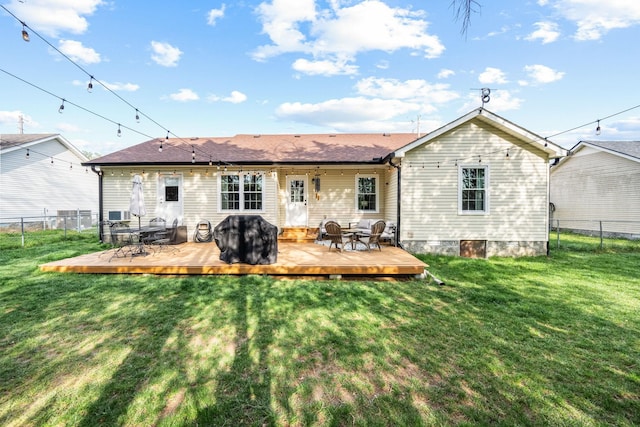 rear view of property with a fenced backyard, a wooden deck, and a yard