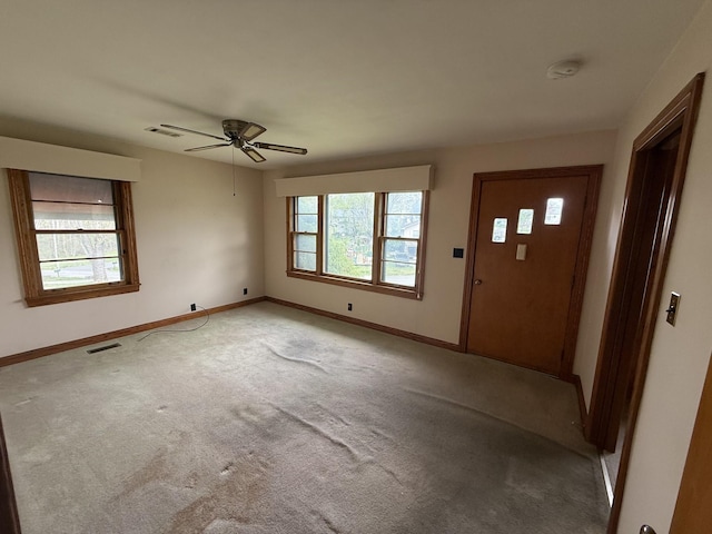 carpeted foyer entrance featuring baseboards, visible vents, and a ceiling fan