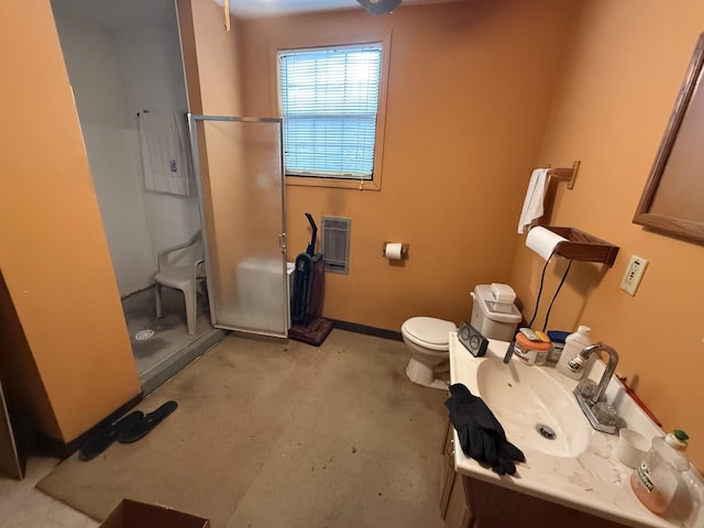 bathroom with toilet, vanity, a stall shower, and baseboards