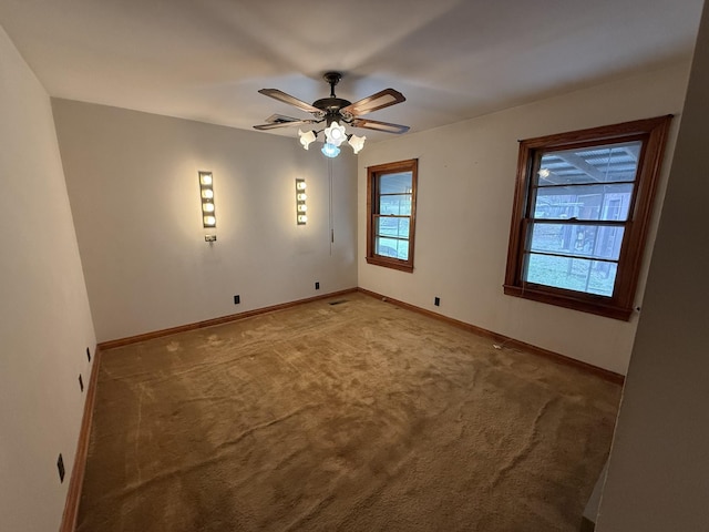 unfurnished room with light colored carpet, baseboards, and a ceiling fan