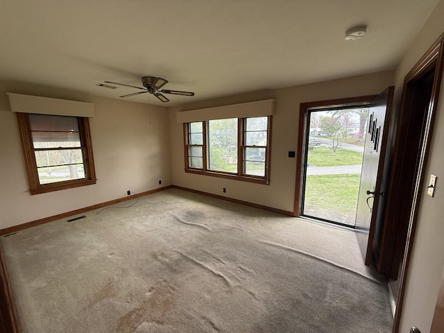 empty room featuring baseboards, visible vents, and carpet floors
