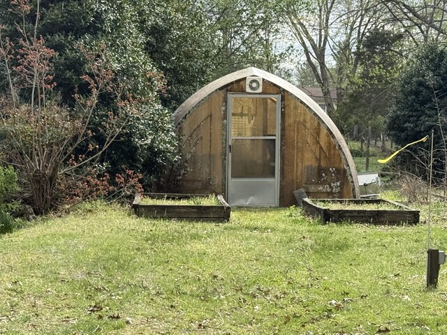 view of greenhouse featuring a yard