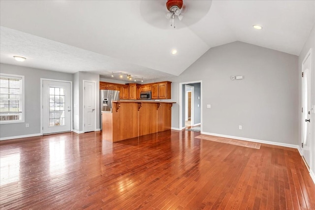 unfurnished living room featuring baseboards, vaulted ceiling, ceiling fan, and dark wood-style flooring