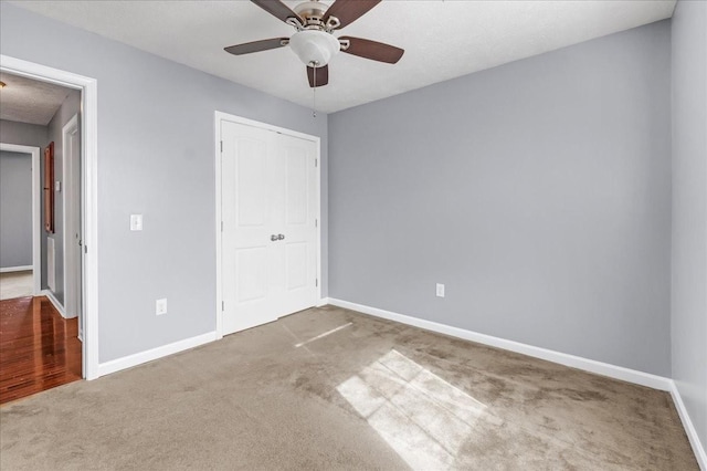 unfurnished bedroom with carpet flooring, a closet, and baseboards