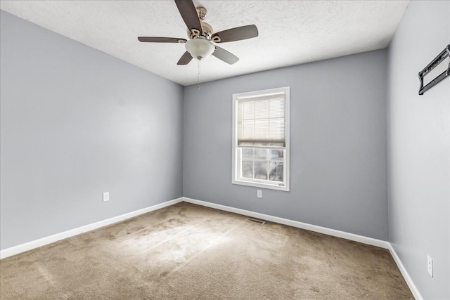 carpeted empty room featuring baseboards, visible vents, a textured ceiling, and a ceiling fan