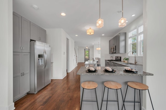 1603A 9th Ave N, Nashville, TN 37208 - kitchen featuring gray cabinetry, a kitchen bar, a sink, and appliances with stainless steel finishes