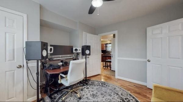 home office featuring a ceiling fan, wood finished floors, and baseboards