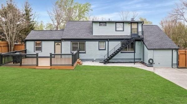 back of house with a deck, driveway, stairs, roof with shingles, and a chimney