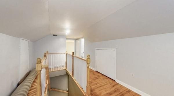 bonus room featuring wood finished floors, vaulted ceiling, and baseboards