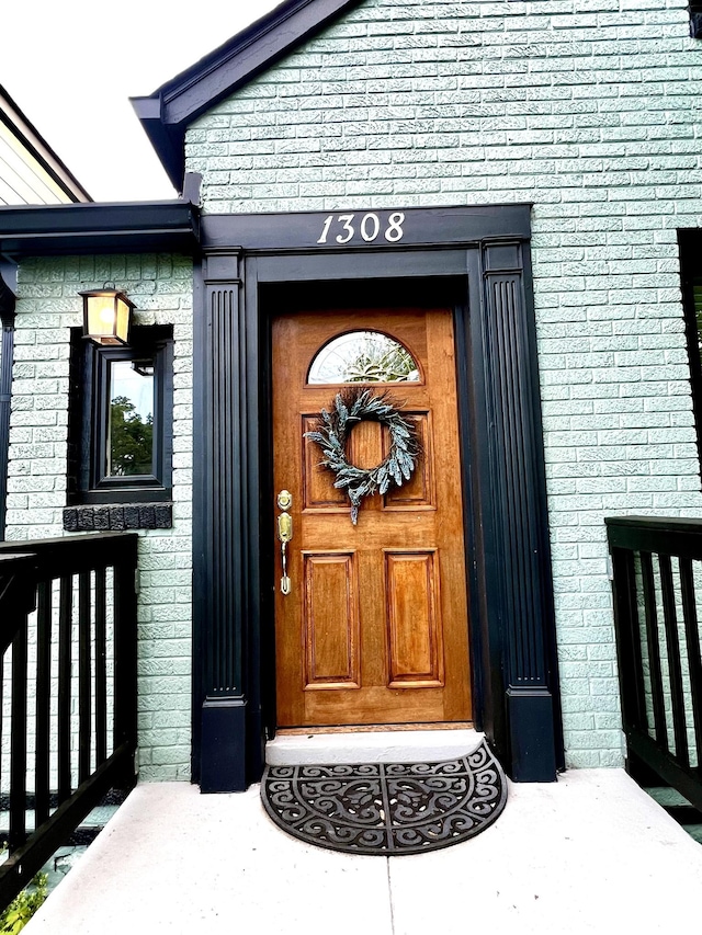 doorway to property with brick siding