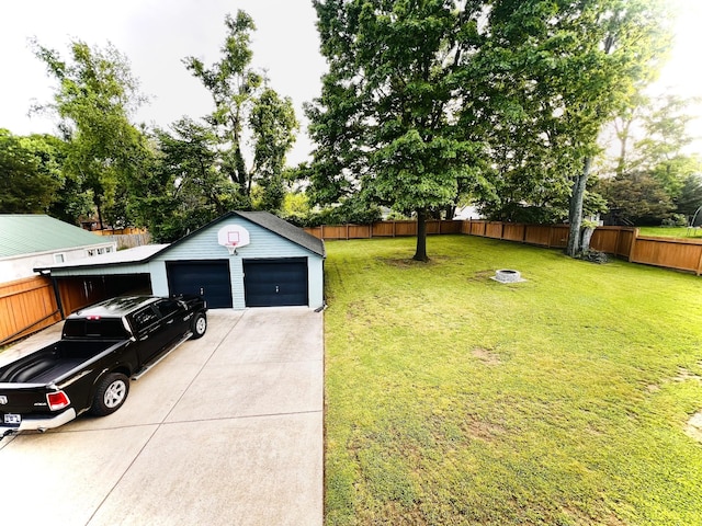 view of yard featuring an outdoor structure, driveway, and an attached garage
