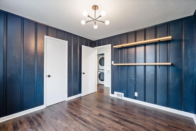 212 S Sequoia Dr, Springfield, TN 37172 - unfurnished bedroom featuring a chandelier, wood finished floors, stacked washer / dryer, a decorative wall, and visible vents