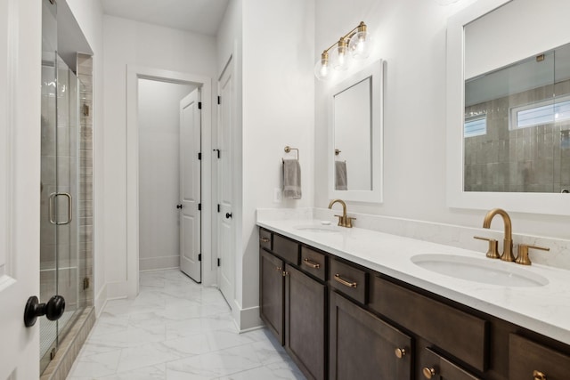 bathroom with marble finish floor, a sink, a stall shower, and double vanity