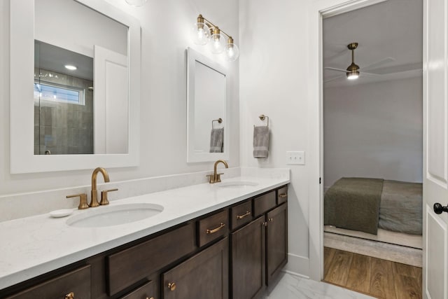 bathroom with marble finish floor, double vanity, a sink, and a ceiling fan