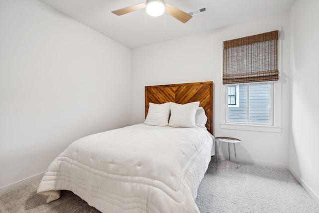 carpeted bedroom with baseboards, visible vents, and a ceiling fan