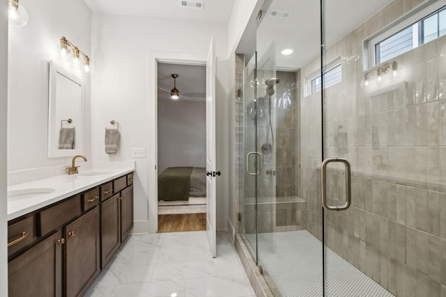 ensuite bathroom featuring a shower stall, marble finish floor, a sink, ceiling fan, and visible vents