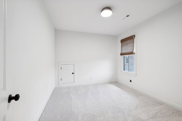 empty room featuring baseboards, visible vents, and carpet