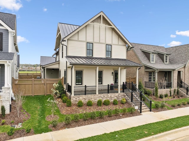 view of front of property with metal roof, a standing seam roof, fence, and a porch