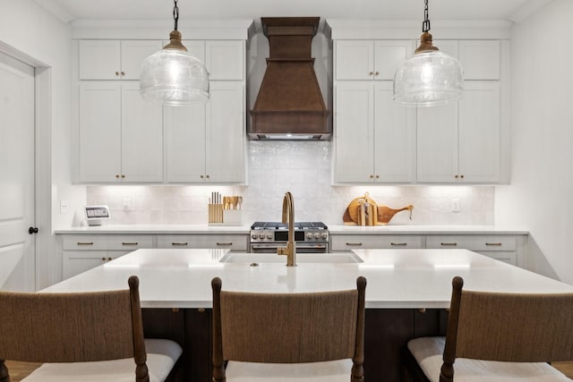 kitchen featuring pendant lighting, decorative backsplash, and premium range hood