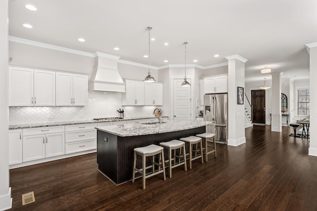 1701 Glen Echo Rd, Nashville, TN 37215 - kitchen with a kitchen island with sink, premium range hood, appliances with stainless steel finishes, a sink, and a breakfast bar area