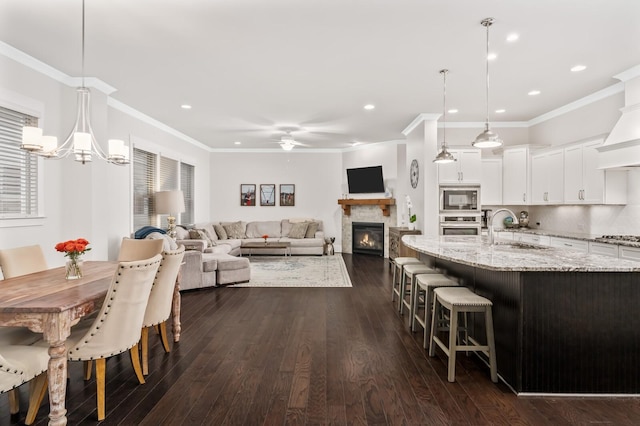 1701 Glen Echo Rd, Nashville, TN 37215 - dining area with plenty of natural light, ornamental molding, dark wood finished floors, ceiling fan with notable chandelier, and a glass covered fireplace