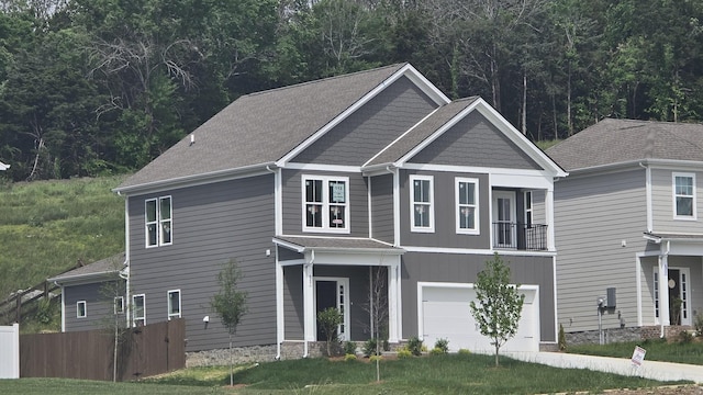 craftsman inspired home with an attached garage and fence