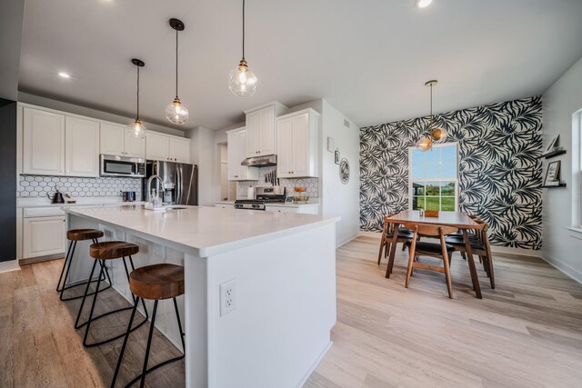 17 Kilkham Ct, Mount Juliet, TN 37122 - kitchen featuring tasteful backsplash, light countertops, under cabinet range hood, stainless steel appliances, and a sink