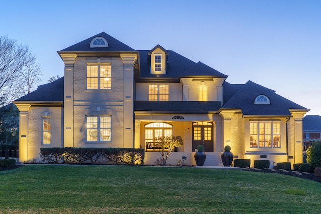 9812 Windrose Cir, Chattanooga, TN 37421 - back of property at dusk featuring brick siding, covered porch, and a yard