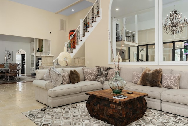 9812 Windrose Cir, Chattanooga, TN 37421 - living room featuring visible vents, a chandelier, a towering ceiling, stone tile flooring, and arched walkways