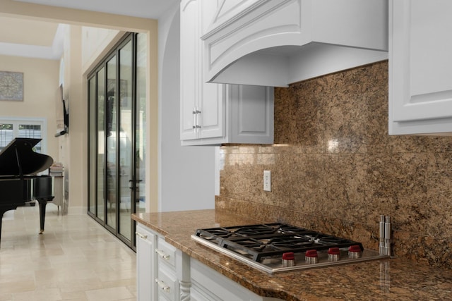 9812 Windrose Cir, Chattanooga, TN 37421 - kitchen with white cabinetry, stainless steel gas cooktop, custom range hood, backsplash, and arched walkways