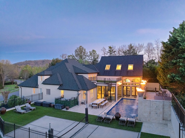 9812 Windrose Cir, Chattanooga, TN 37421 - back of property at dusk featuring a patio area, a fenced in pool, stucco siding, fence, and a yard
