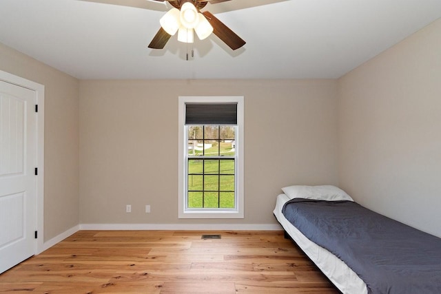 bedroom with baseboards, ceiling fan, and wood finished floors