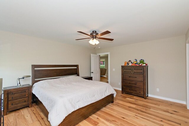 bedroom featuring baseboards, light wood-style floors, and ceiling fan