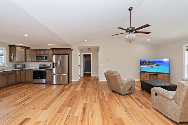 kitchen with open floor plan, light wood-style flooring, stainless steel appliances, and visible vents