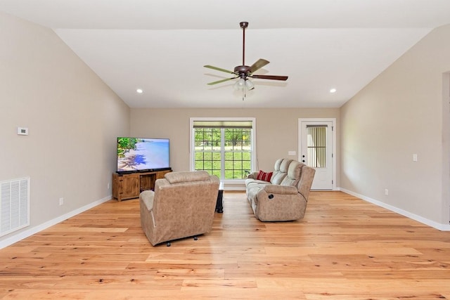 living room with visible vents, baseboards, a ceiling fan, lofted ceiling, and light wood-style floors