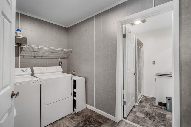 washroom with washer and dryer, laundry area, and tile walls