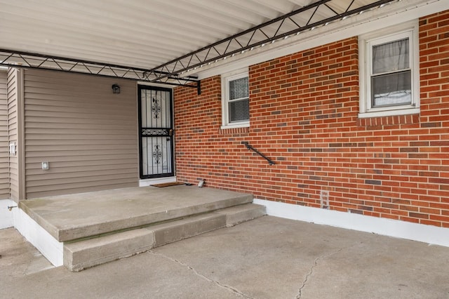 view of exterior entry featuring brick siding