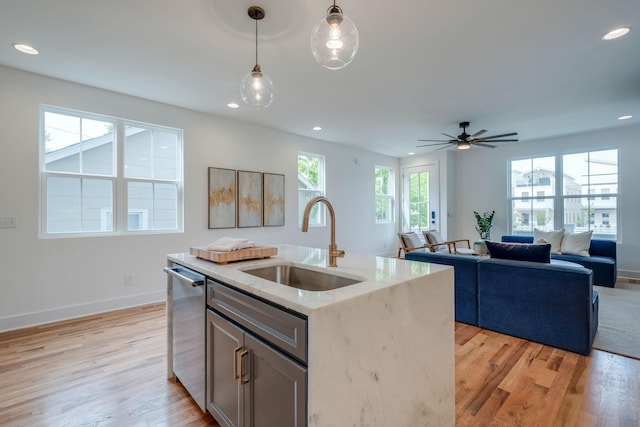 808A 45th Ave N, Nashville, TN 37209 - kitchen featuring stainless steel dishwasher, light wood finished floors, decorative light fixtures, and a sink